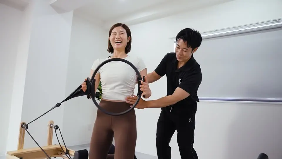 笑顔のお客様に寄り添い、ピラティスの動きを支えるスタッフ